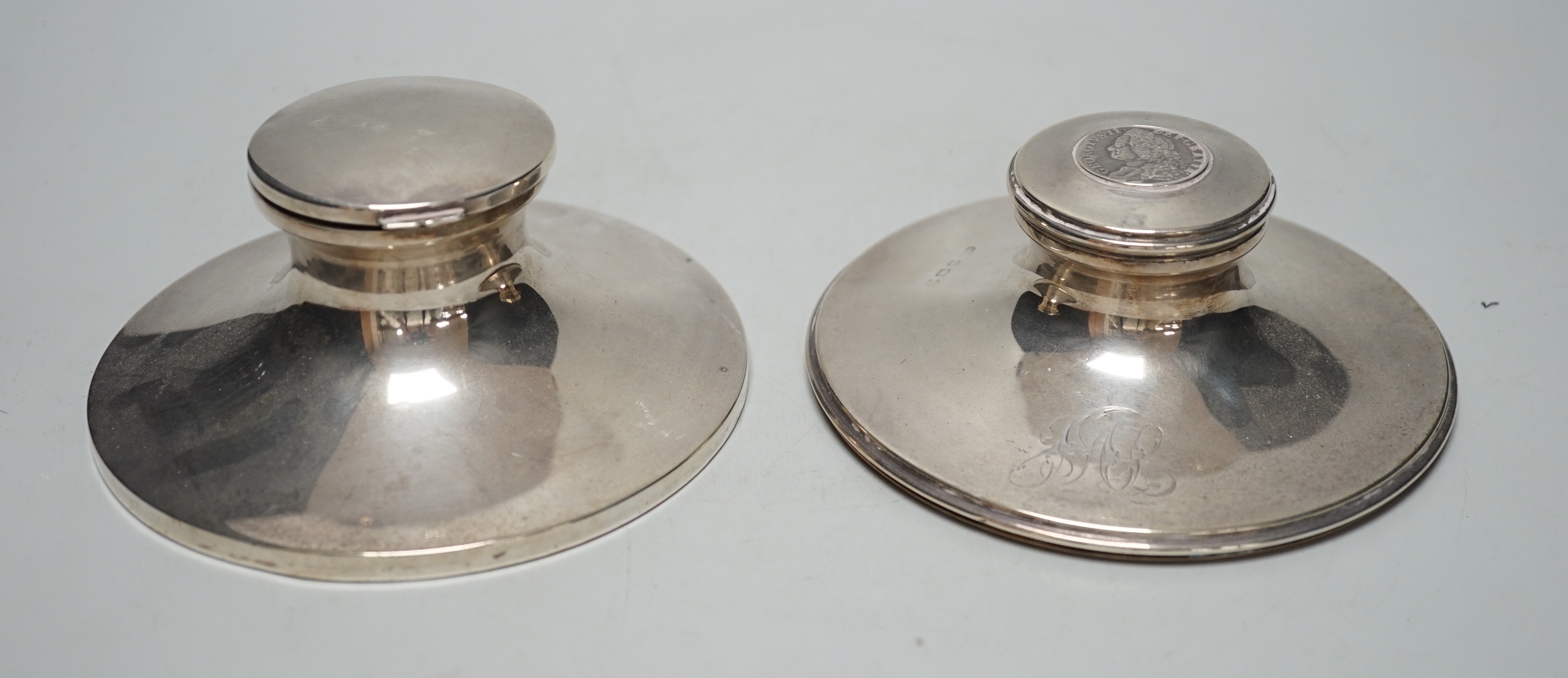 A George V silver mounted capstan inkwell, by Mappin & Webb, London, 1916, diameter 13.6cm and one other silver mounted capstan inkwell.